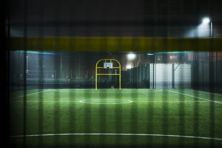 Fluter beleuchten abends einen kleinen Sportplatz