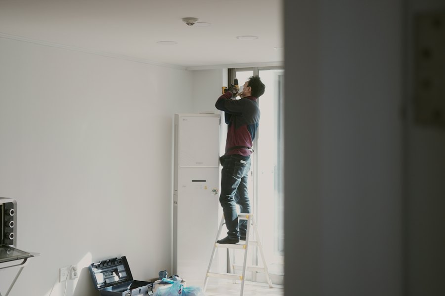Monteur arbeitet auf einer Leiter an der Decke